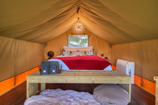 Tent interior with bed and red bedspread