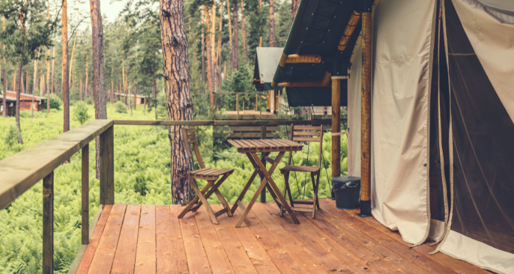 Safari Glamping Tent with outdoor picnic table in the forest