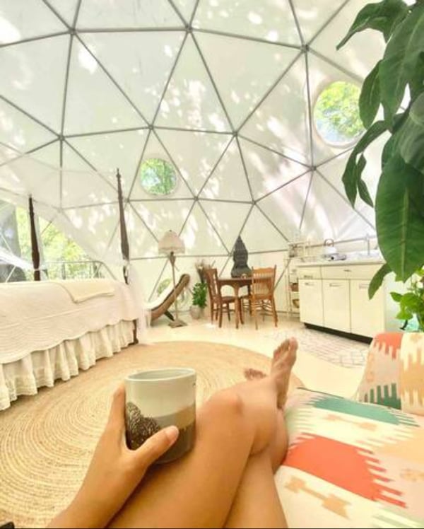 Person resting with tea inside spacious dome