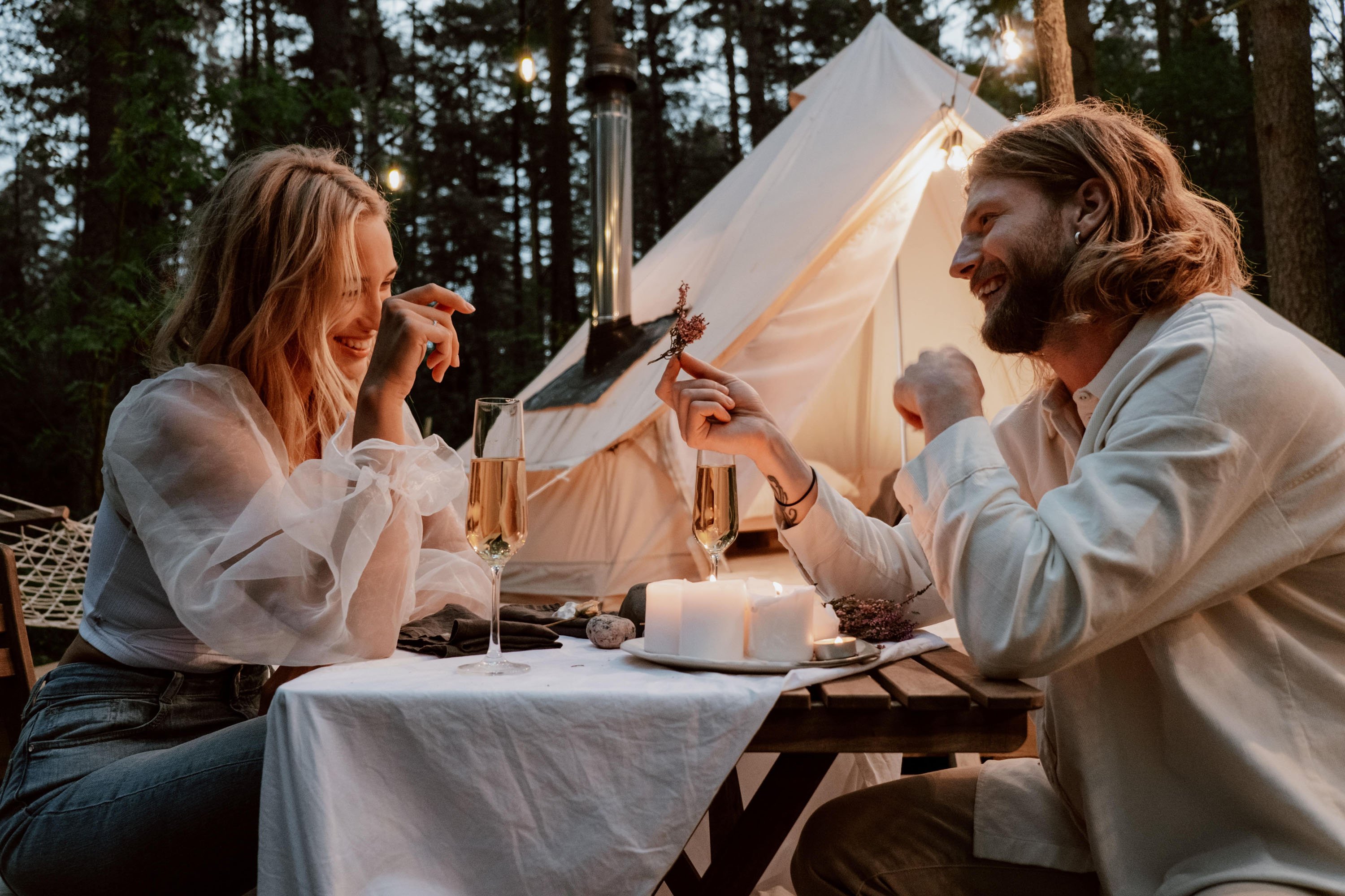 couple sharing meal in front of tent at twilight