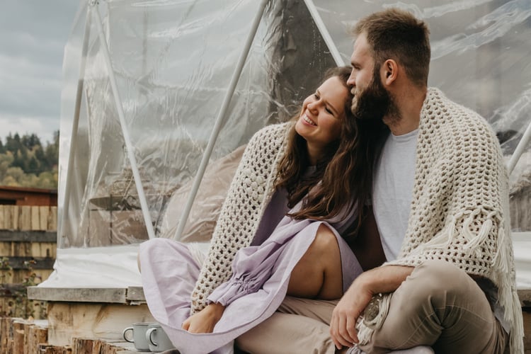 couple sitting together outside glamping tent